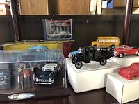 Full display of four model vehicles, boxed sets, and train car