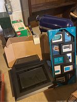 Multiple black picture frames and photo album boxes in cardboard box, lego boxes visible but lego excluded from lot