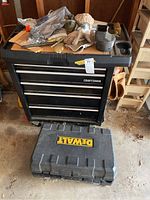Full view of Craftsman tool chest with Dewalt case on ground and miscellaneous tools and gloves on top.