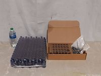 Two lots of cobalt blue glass bottles: one unopened pack wrapped in plastic and an open set with bottles standing next to a water bottle for scale.