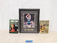 Photo of Larry Bird framed picture flanked by two books about Larry Bird