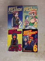 Front covers of four Scott Pilgrim graphic novels volumes 2, 4, 5, and 6 laid out on a surface.