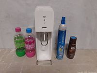 Full view of SodaStream machine with two plastic bottles, CO2 cylinder, and root beer mix bottle.