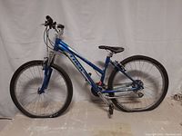 Full side view of the blue Trek Skye 5 mountain bike showing frame, tires, saddle, and handlebars.