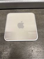 Top view of Apple AirPort Extreme wireless router showing silver aluminum surface with Apple logo.