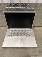 Apple PowerBook G4 laptop opened showing keyboard and screen, silver aluminum body.