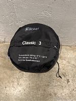 Top view of the black compression sack with Outbound logo and Classic 3 model name, showing temperature rating, dimensions and filling information.