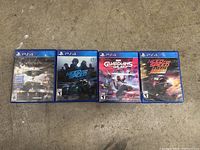 Photo showing 4 PS4 game cases laid out on a concrete floor, titles visible: Batman: Arkham Knight, Need for Speed Rivals, Marvel's Guardians of the Galaxy, Need for Speed Payback.