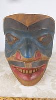Front view of carved mask showing painted facial features