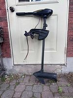 Full view of trolling motor standing upright showing housing, shaft, propeller and clamp mount