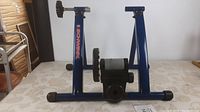 Front view of Schwinn blue bike trainer stand with visible brand name and resistance unit