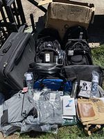Overview photo showing all bags including suitcase, backpacks, apparel, bottles, notebooks, and swag items outdoors
