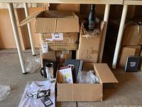 Boxes filled with assorted Landmark swag including bottles, shirts, notebooks, and mugs.