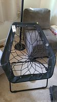 Front view of Bunjo Bunji lounge chair showing black bungee web seating within hexagonal metal frame and angled legs.