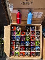 Open cardboard box interior showing 30 assorted colored bottles packed in individual compartments