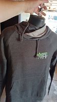 Gray hoodie with WFP logo shown hanging, displaying front pocket and drawstring hood.