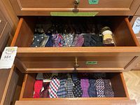 Two wooden drawers, top shows neckties, bottom shows bow ties arranged in two rows