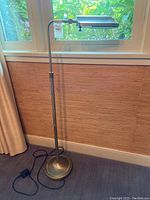 Full view of the Verilux floor lamp standing on carpet with adjustable height and arm visible.