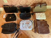 Full view of nine purses and bags showing styles, colors, and materials.