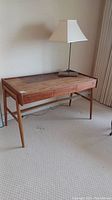 Front view of teak desk with lamp on top