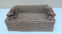 Single largest wicker basket with wooden handles shown from front angle.