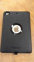 Back view of Apple tablet in black OtterBox case showing Apple logo and OtterBox branding