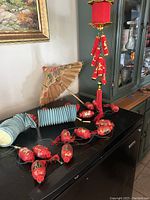 Photo showing red lantern string lights unlit on table near a decorative hand fan and paper tape rolls