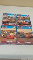 Four boxed 48-piece Disney Pixar Cars puzzles showing colorful illustrations of characters and scenes from the Cars movies.