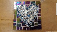 Front view of the 6x6 inch mosaic artwork displaying the heart made from blue and white patterned crockery with surrounding iridescent tiles.
