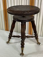 Front and side view showing claw feet with glass balls and fluted legs, round stool seat with visible wear