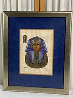 Framed papyrus print showing the entire piece with silver frame and blue double mat.