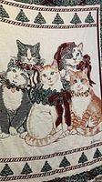 Close-up of vintage tapestry throw blanket featuring five cats with Christmas attire and Christmas tree borders.