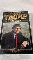 Photo of vintage Trump board game box front cover with image of Donald J. Trump, showing title and condition of box.