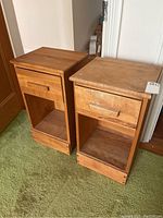Two matching nightstands side by side on green carpet
