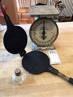 Overall display of all three items: kitchen scale, cast iron pastry maker, and glass stopper.