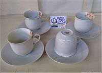 Set of four white Dansk tea/coffee cups and saucers with labels shown