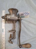 Photo of the full Universal vintage food grinder showing body, handle, clamp, and measurement scale beside it.