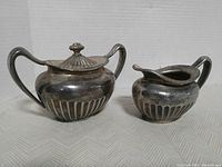 Front view of vintage creamer and sugar bowl on neutral background showing full set.