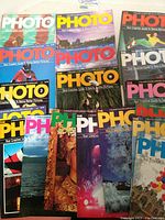 Top view of the lot showing the front covers of the 19 PHOTO magazine issues laid out for display, featuring varied photographic images including wildlife, landscapes, and creative photography.