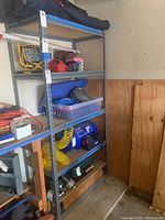 Metal shelving unit with multiple items placed on shelves showing overall condition and contents