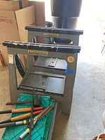 Two gray Storehorse folding sawhorses with paint chipping on edges.