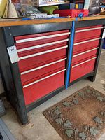 Front view showing two columns of red drawers under wood top