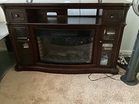 Full front view of the electric fireplace media storage console showing the drawers, open shelf, glass door storage compartments, and the electric fireplace insert.