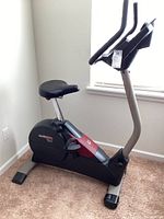 Full side view of the black and gray ProForm 920 SE EKG exercise bike with padded seat and dual handlebars.