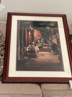 Photo of framed Carol Jessen Cornelia Street print showing an evening street dining scene with warm ambiance, wooden frame and double matting.
