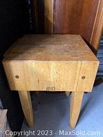 Butcher block island table front view showing thick end-grain top and four legs