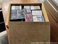 Open view of multiple cassette tapes inside the wooden wine crate showing different tape covers and clear details of tapes and crate interior.