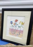 Framed watercolor flower painting by Mark Poduol showing colorful stylized flowers with roots, in black frame and white mat.