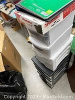 Stacked plastic drawer units with boxes and items on top.