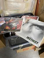 Photo shows a large file box filled with multiple original film magazines, some prominently showing covers from films including 'Instinct' and 'Empire' with glossy pages intact.